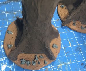 Adding some rocks to the base of the jungle trees for wargaming terrain
